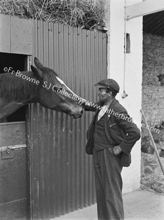 GENT WITH RACEHORSE AT STABLE